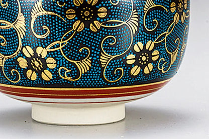 Ceramic bowl with blue and gold floral patterns on a white background