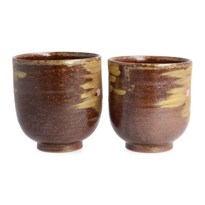 Two brown ceramic cups with marbled design on a white background