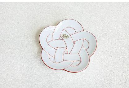 Decorative plate with a knot design on a textured white background. Japanese Ceramics. Made in Japan.