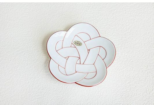 Decorative plate with a knot design on a textured white background. Japanese Ceramics. Made in Japan.
