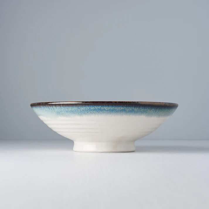 Ceramic bowl with a blue rim on a gray background