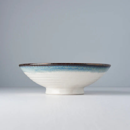 Ceramic bowl with a blue rim on a gray background