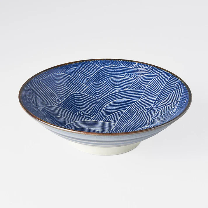Ceramic bowl with blue wave pattern on a white background