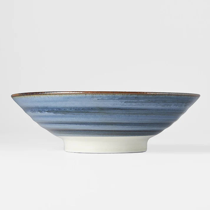 Ceramic bowl with blue and white striped design on a light gray background