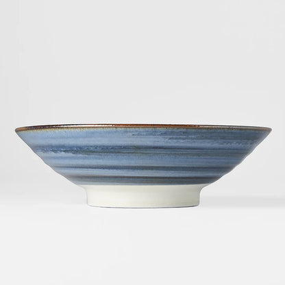 Ceramic bowl with blue and white striped design on a light gray background