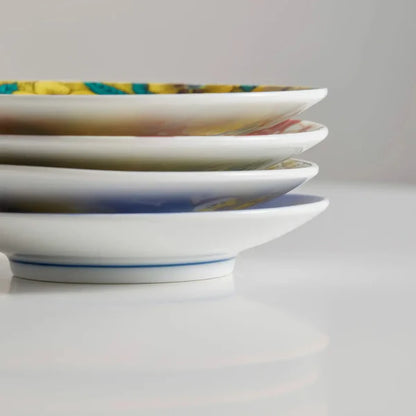 Stack of ceramic plates with decorative patterns on a white surface