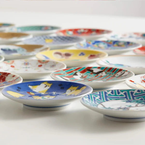 Collection of colorful ceramic plates with various designs on a white background