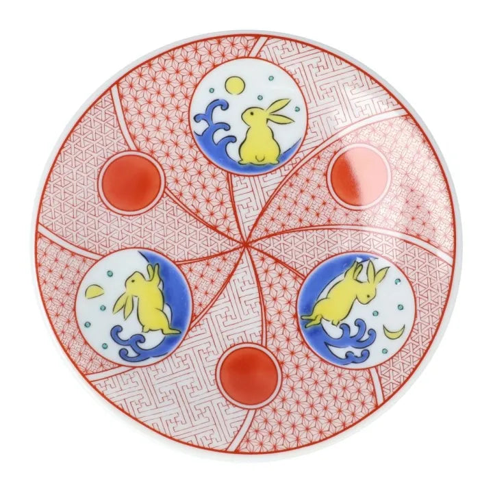 Decorative plate with rabbit designs and red geometric patterns on a white background