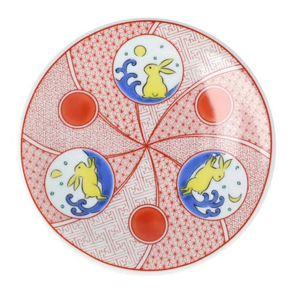 Decorative plate with rabbit designs and red geometric patterns on a white background