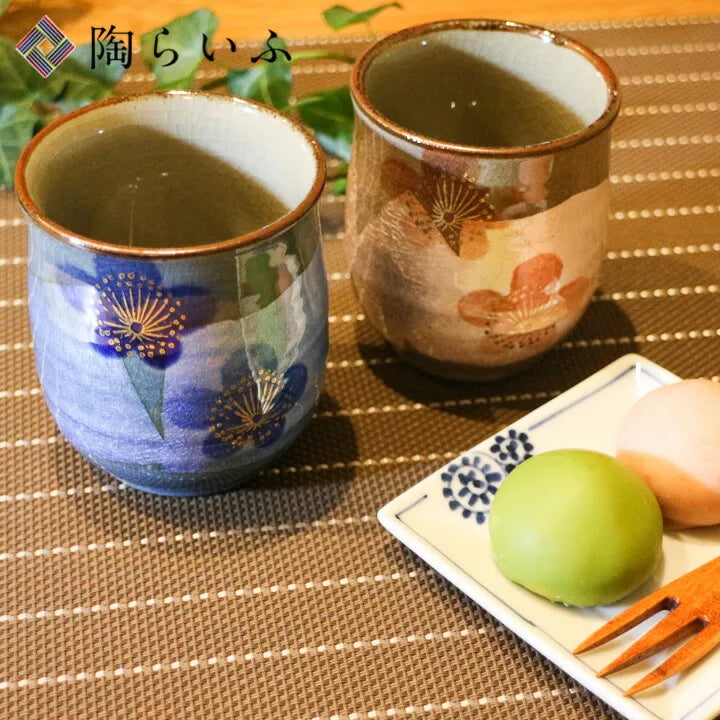 Two ceramic cups with green tea and a small plate of green tea cookies on a textured surface.