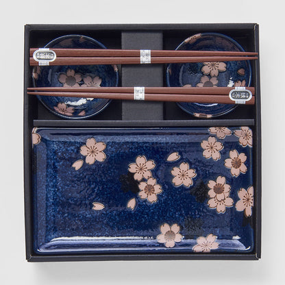 Set of blue ceramic dishes with floral patterns and wooden chopsticks in a black box.