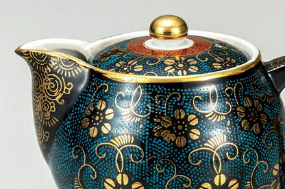 Decorative teapot with gold floral patterns on a blue background