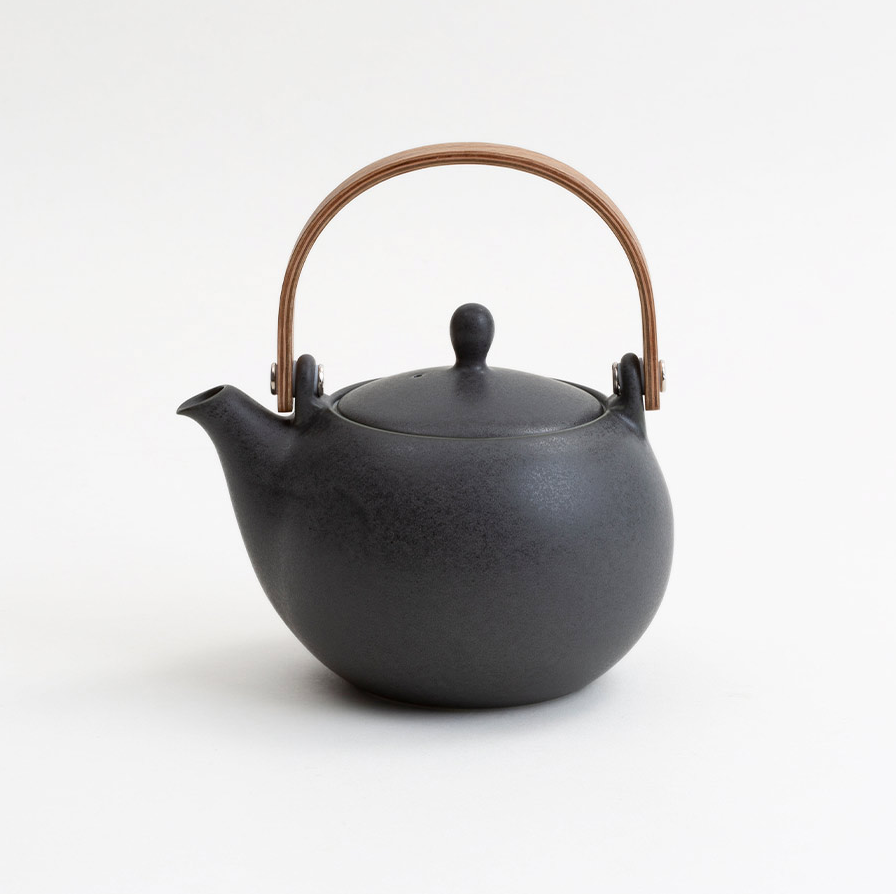 Black teapot with a brown handle on a white background