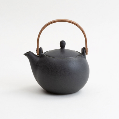 Black teapot with a brown handle on a white background