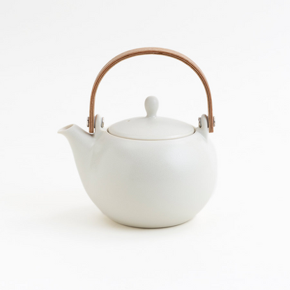White teapot with a bronze handle on a white background