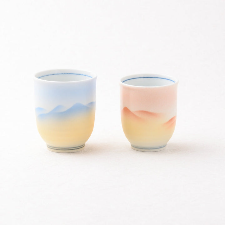 Two ceramic cups with gradient designs on a white background